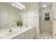 Bathroom with double sink vanity, a shower/tub combination, and decorative mirror at 122 N Fern Abbey Ln, Cary, NC 27518