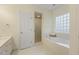 Neutral bathroom featuring soaking tub with glass block window, a shower, and a sink at 122 N Fern Abbey Ln, Cary, NC 27518