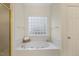 Bright bathroom featuring a large soaking tub with jets and a glass block window at 122 N Fern Abbey Ln, Cary, NC 27518
