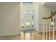 Bright foyer featuring hardwood floors, decorative glass front door, and staircase with white railing at 122 N Fern Abbey Ln, Cary, NC 27518