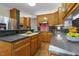 Kitchen with wood cabinets, stainless steel appliances, tile backsplash, and black countertops at 122 N Fern Abbey Ln, Cary, NC 27518