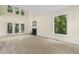 Bright living room featuring a fireplace and large windows overlooking lush greenery at 122 N Fern Abbey Ln, Cary, NC 27518