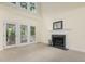 Cozy living room with a fireplace, mantle, and access to the outdoor patio at 122 N Fern Abbey Ln, Cary, NC 27518