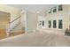 Open-concept living room with hardwood floors, staircase, and French doors to deck at 122 N Fern Abbey Ln, Cary, NC 27518