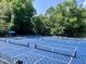 Several tennis courts with blue surfaces in a treed community at 122 N Fern Abbey Ln, Cary, NC 27518