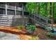 Rear of home featuring wooden deck with railings, stairs and green trees at 128 Shadowbrook, Pittsboro, NC 27312
