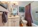 Well-lit bathroom featuring a vanity, toilet, and bathtub with shower curtain at 128 Shadowbrook, Pittsboro, NC 27312
