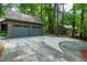 Home featuring attached two-car garage and paved driveway surrounded by green trees at 128 Shadowbrook, Pittsboro, NC 27312
