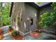 Side view of home featuring the front door with brick entrance and native landscaping at 128 Shadowbrook, Pittsboro, NC 27312