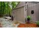 A side exterior showing the home's architectural details, a wooden deck, and natural landscaping at 128 Shadowbrook, Pittsboro, NC 27312