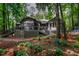 Exterior of home featuring a wooden deck with black metal railings surrounded by landscaping at 128 Shadowbrook, Pittsboro, NC 27312