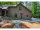 Side exterior of the home featuring updated landscaping, a winding walkway, and architectural details at 128 Shadowbrook, Pittsboro, NC 27312