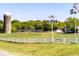 Scenic view of a charming farm with a white fence, silo, and lush green fields on a clear, sunny day at 128 Shadowbrook, Pittsboro, NC 27312
