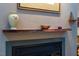 Close up of the fireplace with its unique wooden mantle and decorative items at 128 Shadowbrook, Pittsboro, NC 27312
