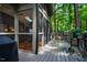 View of an enclosed porch and covered deck area with outdoor seating and grill at 128 Shadowbrook, Pittsboro, NC 27312