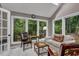 Relaxing sunroom features a skylight, large windows with green tree views, and tile flooring at 128 Shadowbrook, Pittsboro, NC 27312