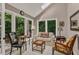 Inviting sunroom with a skylight and a wall of windows showing mature trees outside at 128 Shadowbrook, Pittsboro, NC 27312
