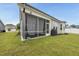 A screened back porch with outdoor furniture, offering a relaxing space with views of the backyard at 129 Alumroot Rd, Holly Springs, NC 27540