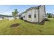 A backyard featuring large windows, new landscaping, a grill, and an enclosed back porch at 129 Alumroot Rd, Holly Springs, NC 27540