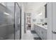 Bathroom view highlighting double vanity, tiled floors, walk-in shower, and adjacent bedroom at 129 Alumroot Rd, Holly Springs, NC 27540