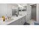 Bathroom with dual sinks, white countertops, gray cabinets, modern lighting, and walk-in shower at 129 Alumroot Rd, Holly Springs, NC 27540