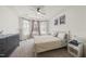 Bedroom featuring a bay window, tray ceiling, patterned bedding, and decor art on the wall at 129 Alumroot Rd, Holly Springs, NC 27540