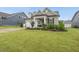 Charming home with a manicured lawn, a two-car garage, and a welcoming front porch with tasteful landscaping at 129 Alumroot Rd, Holly Springs, NC 27540
