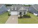 Charming home with a well-manicured lawn, inviting porch and an attached two-car garage at 129 Alumroot Rd, Holly Springs, NC 27540