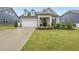 Charming home with a manicured lawn, a two-car garage, and a welcoming front porch with tasteful landscaping at 129 Alumroot Rd, Holly Springs, NC 27540