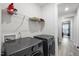 Bright laundry room featuring modern washer and dryer appliances and ample storage shelving at 129 Alumroot Rd, Holly Springs, NC 27540