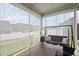 Screened patio with outdoor swing sofa, patterned tile floors, and backyard view at 129 Alumroot Rd, Holly Springs, NC 27540