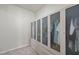 Walk-in closet showcasing a custom shelving system with glass doors, and carpet floors at 129 Alumroot Rd, Holly Springs, NC 27540