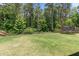 A large, well-maintained backyard features a lush lawn, trampoline, and mature trees for privacy and shade at 145 Bounding Ln, Youngsville, NC 27596