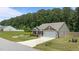 Exterior showcasing a well-manicured lawn, two car garage, and picturesque pond at 145 Bounding Ln, Youngsville, NC 27596