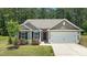 Charming home featuring a two-car garage, well-maintained lawn, and beautiful landscaping at 145 Bounding Ln, Youngsville, NC 27596