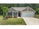 Charming home featuring a two-car garage, well-maintained lawn, and beautiful landscaping at 145 Bounding Ln, Youngsville, NC 27596