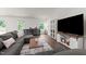 Bright living area with a comfortable sectional sofa, large windows, and stylish entertainment center at 145 Bounding Ln, Youngsville, NC 27596