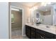 Bathroom featuring double sinks, a large mirror, and view into additional room at 157 Lynn Dr, Clayton, NC 27520