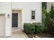 Exterior entryway with lush shrubs, painted door, garage door and a side window with bright sunlight at 157 Lynn Dr, Clayton, NC 27520