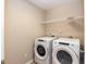 Bright laundry room featuring a modern washer and dryer, with a wire shelf for added storage at 157 Lynn Dr, Clayton, NC 27520