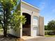 View of a multi-story barn structure with open doors, surrounded by lush greenery at 1624 Hopkins Rd, Bahama, NC 27503
