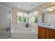 Bathroom featuring a jacuzzi tub, floral wallpaper, and a window at 1624 Hopkins Rd, Bahama, NC 27503