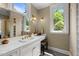 Bright bathroom with a large mirror, vanity, white cabinets, and natural lighting at 1624 Hopkins Rd, Bahama, NC 27503