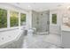 Bright bathroom featuring a large window, jacuzzi tub, glass enclosed shower, and dual sink vanity at 1624 Hopkins Rd, Bahama, NC 27503