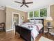Comfortable bedroom with hardwood floors, ceiling fan, and views into the luxurious Primary bath at 1624 Hopkins Rd, Bahama, NC 27503