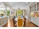 Bright dining area with hardwood floors, large windows offering a view, and elegant decor at 1624 Hopkins Rd, Bahama, NC 27503