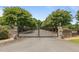 Grand gated entrance to Winding Creek Farm, lined with mature trees and brick pillars at 1624 Hopkins Rd, Bahama, NC 27503