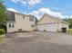 Side view of a two-story home with an attached two-car garage and a large concrete driveway at 1624 Hopkins Rd, Bahama, NC 27503