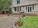 Charming home exterior featuring brick stairs, elegant white columns, and mature landscaping at 1624 Hopkins Rd, Bahama, NC 27503