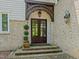 Charming front entrance features double doors, brickwork, arched support, and manicured landscaping at 1624 Hopkins Rd, Bahama, NC 27503